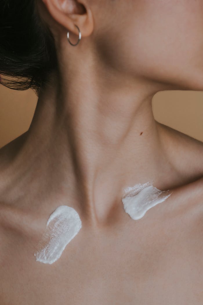 gallery-6 Detailed image showing a woman's neck with skincare cream applied in a studio setting.